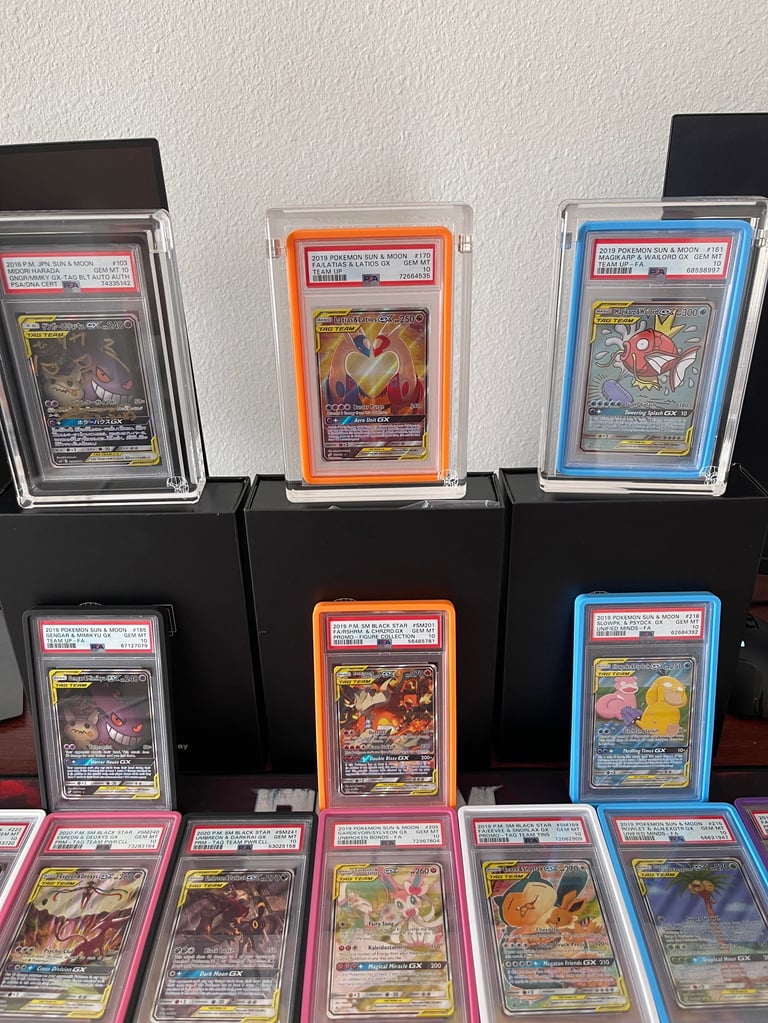 Collection of graded trading cards displayed in protective cases and slabs